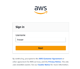 AWS sign-in page with username field, password field, and orange Next button. Includes AWS Customer Agreement and cookie notice text at bottom. 