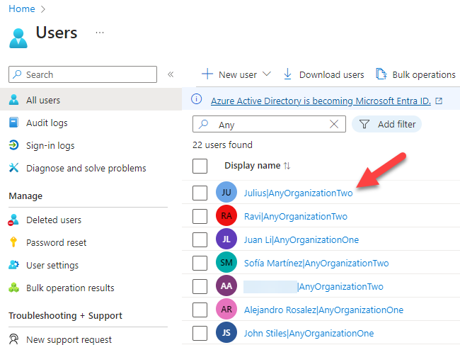 The Azure console displays the All users screen where it has appended the organization name to the Display name to identify which tenant the user came from