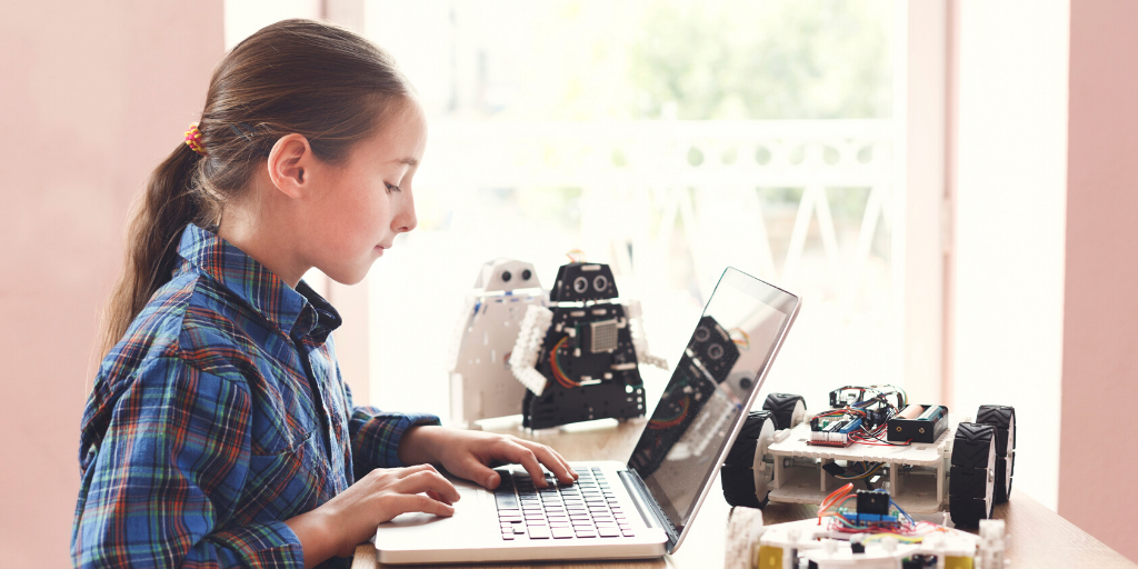 student at laptop programming robot