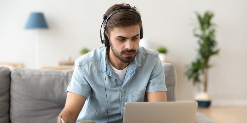 man on headset at laptop remote learning