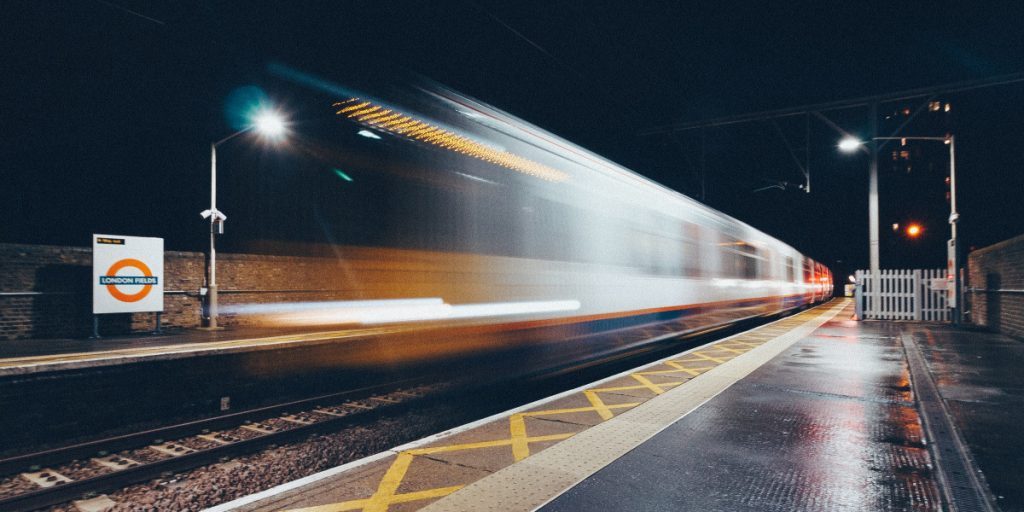 tube train speeding past in a blur at station at night