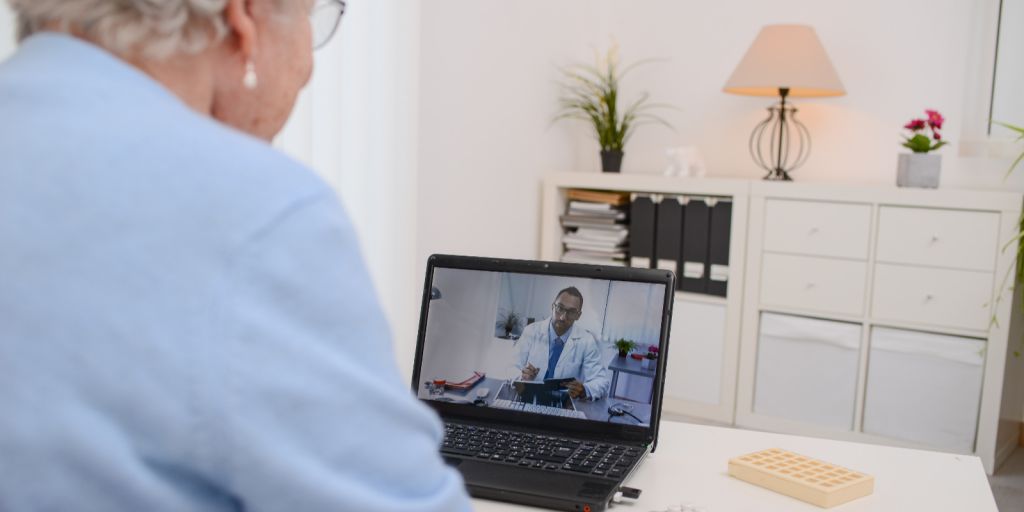 older woman doing telemedicine visit with doctor on laptop