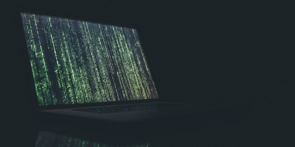 laptop in dark with code on screen; Photo by Markus Spiske on Unsplash