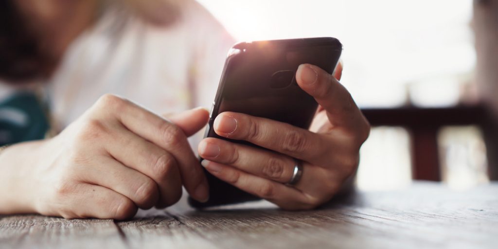 close up of hands on cell phone