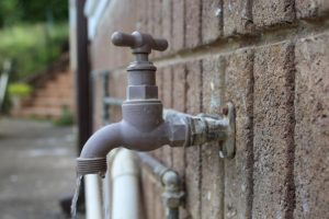 water tap coming out of brick wall