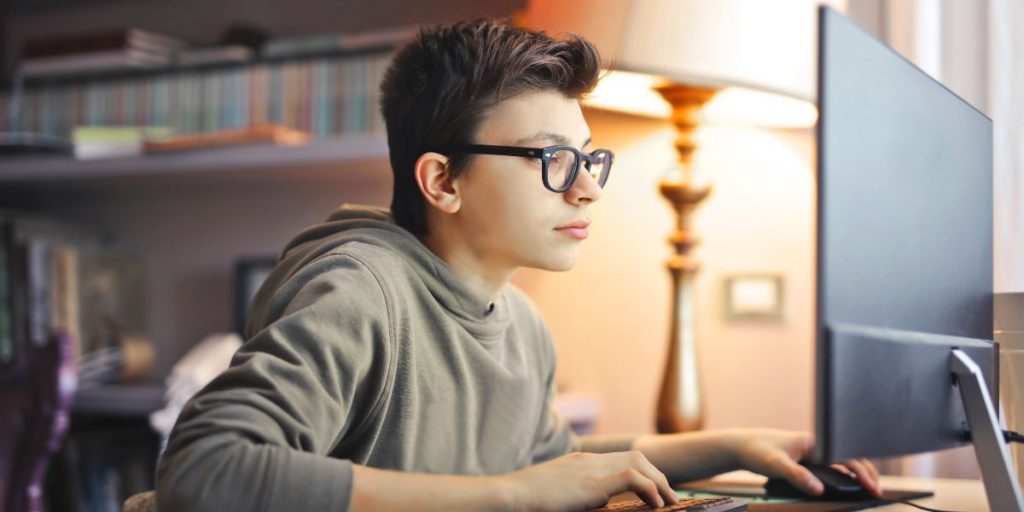 boy playing game on desktop computer