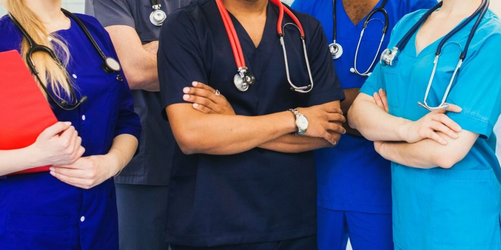 hospital staff standing close together with arms crossed torsos only