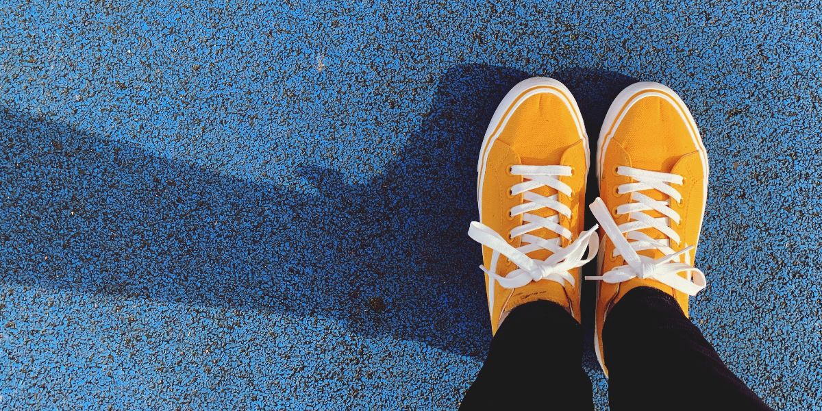 aerial view of yellow sneakers on blue sports surface