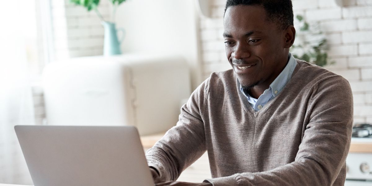 man sitting at a desk on his laptop