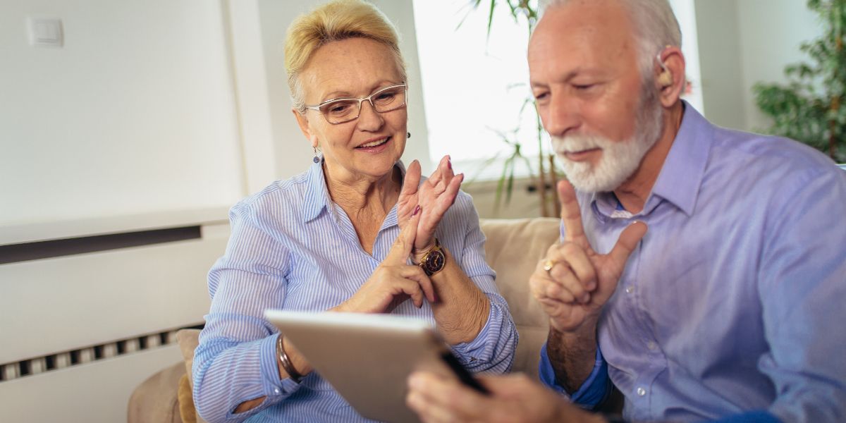 elderly couple signing on tablet