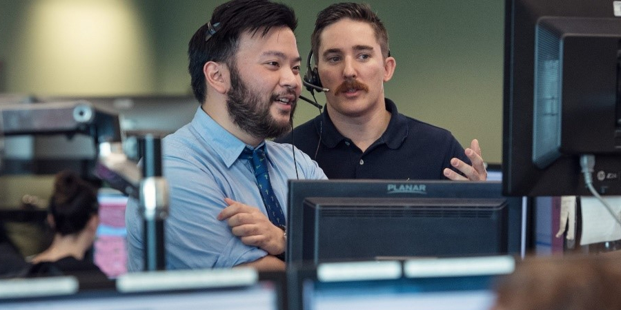 two employees confer at the EComm center