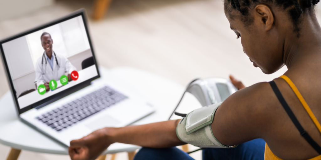 woman takes blood pressure during telehealth session with doctor