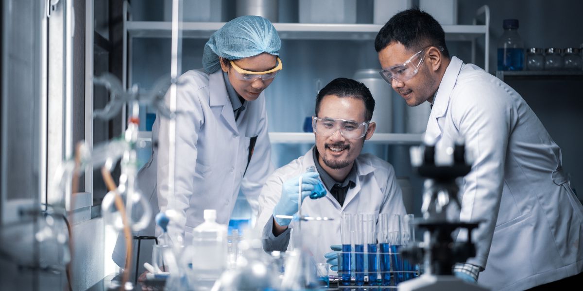 A diverse team of researchers appear excited over a development in their lab.