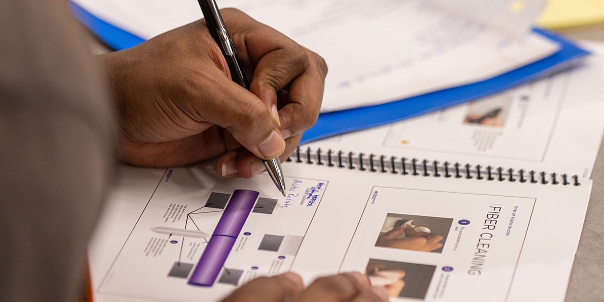 Pictured: A course attendee writes in a notebook from the AWS Fiber Optic Fusion Splicing Course.