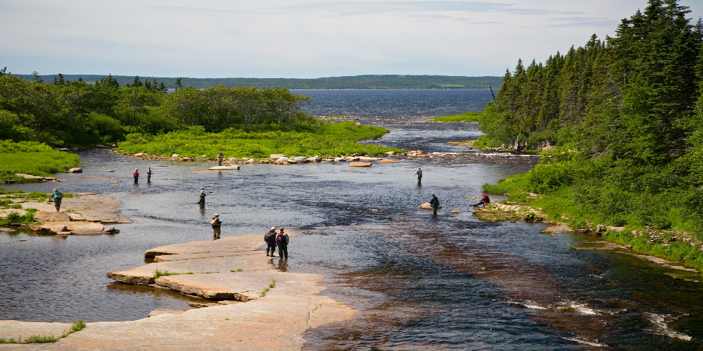 a landscape view of the Torrent River in Canada, with hikers and people fishing