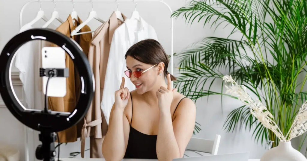 Young-influencer-showing-off-sunglasses-infront-of-phone-camera-with-a-ring-light