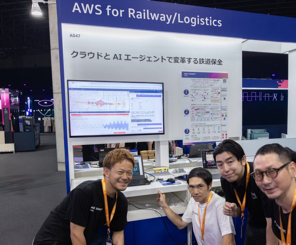 AWS Summit Japan 2026 の「AWS for Railway/Logistics」展示エリアにおける AWS の展示。「クラウドとAIエージェントで変革する鉄道保全」のパネル、デモ画面、セキュリティ設計パネル