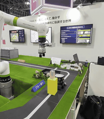 協働ロボットが手先を下向きに保ち、周回路上の障害物を持ち上げて退避させる様子。