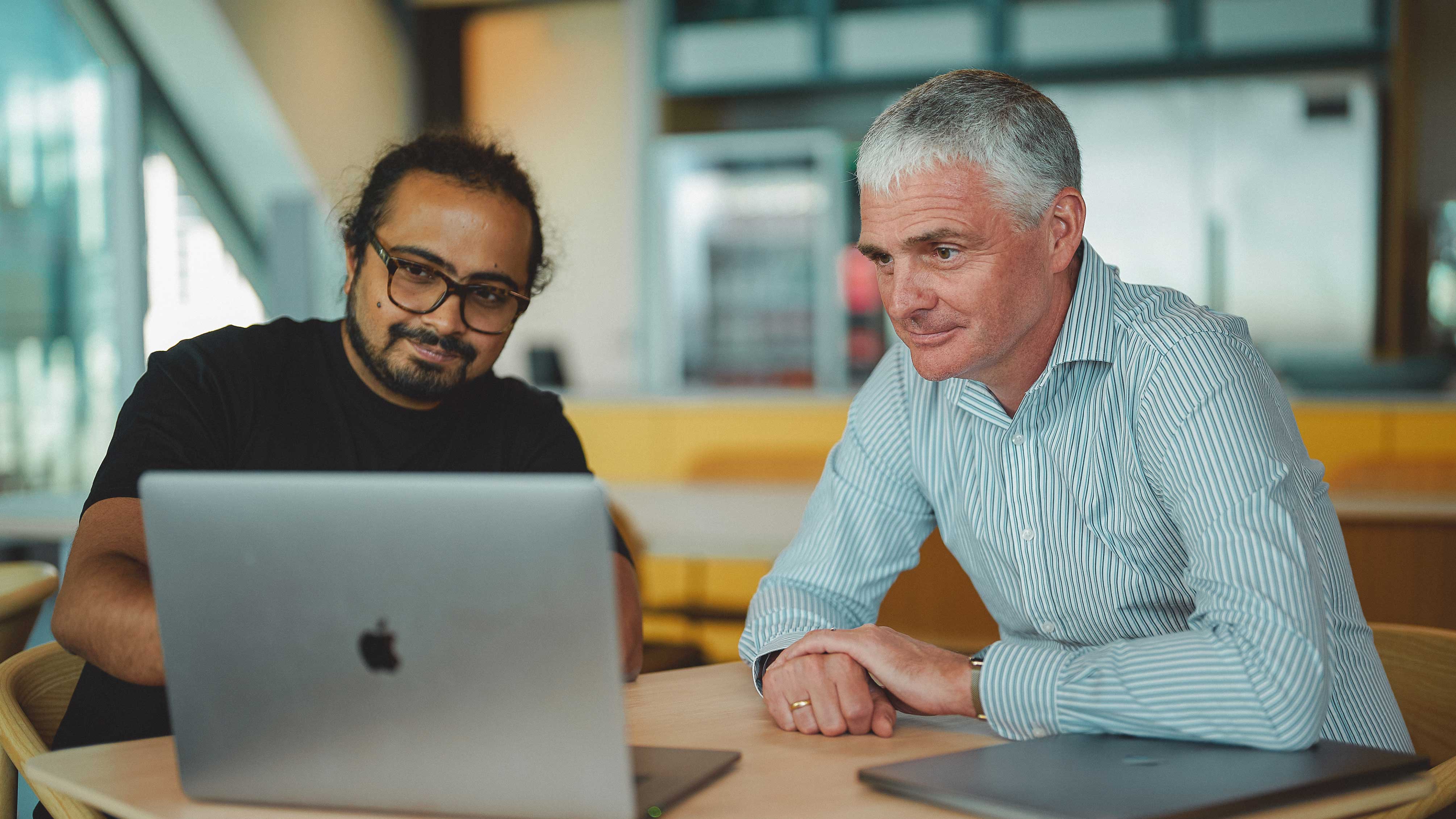 Wine-Searcher CEO and engineer working at desk in front of laptop