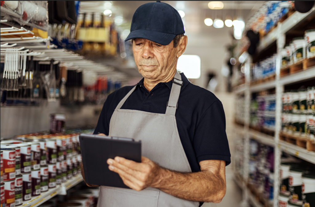 Paint store employee using a tablet to lookup products