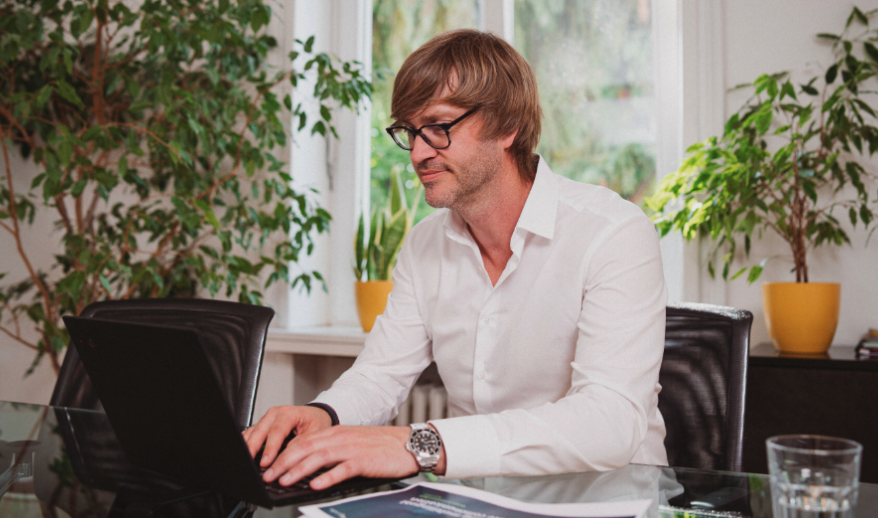 Man at desk in an office setting typing on his computer