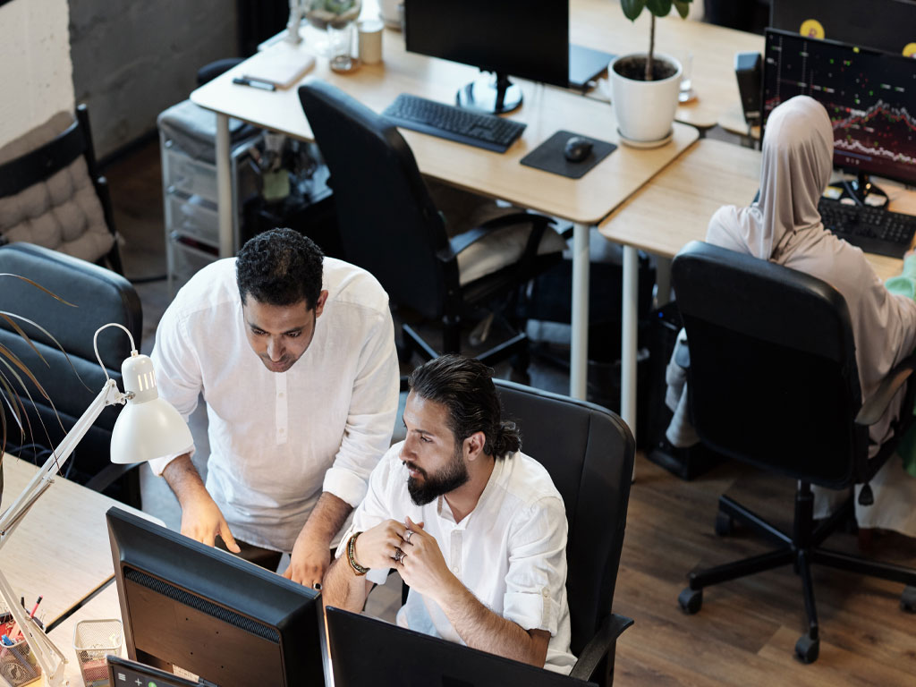 Aerial view of Middle Eastern SMB teammates working at computers