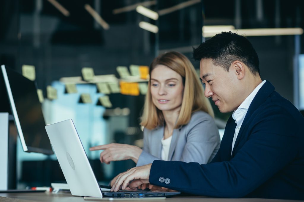 Two coworkers looking at laptop screen