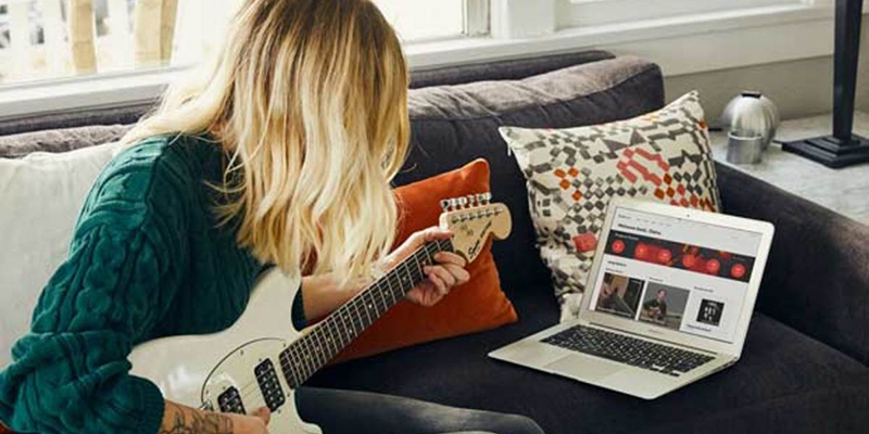 A girl uses Fender Play on her laptop.