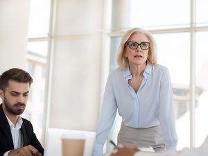 A woman leads a discussion with her team in an office briefing