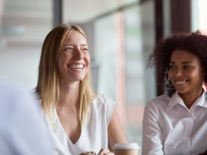 A woman smiling and laughing with a colleague in a business meeting