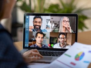 A woman using her laptop to speak with her team in a video conference