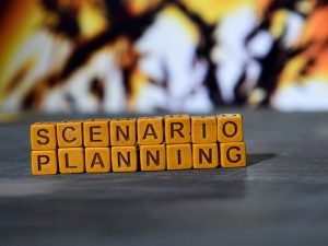 A row of wooden blocks on a table spells out "scenario planning"