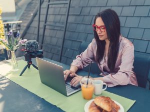 Young woman on the terrace working on laptop