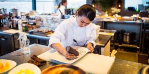 A chef puts the finishing touches on a plate