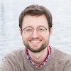 Yann Stoneman portrait - white man in his thirties with slight beard and glasses smiling