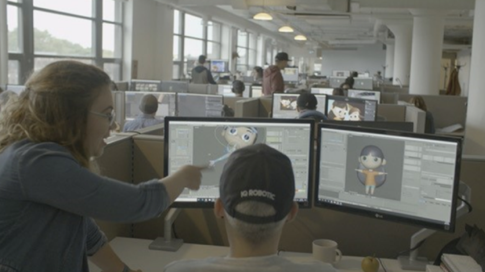 Employees looking at a computer screen with graphics