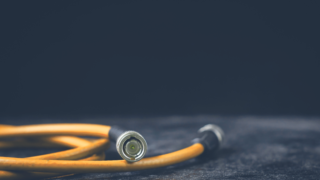 A yellow SDI cable, typically used for on premises video workflows, sits on the ground